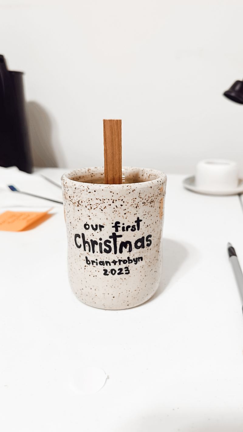 Speckled ceramic candle printed with Our First Christmas